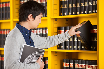 Image showing Male Student Selecting Book In Library