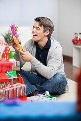 Image showing Smiling Man Holding Christmas Presents At Home