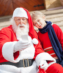 Image showing Santa Claus And Boy Taking Selfportrait Through Smartphone