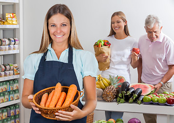 Image showing Saleswoman Holding Carrot Basket At Supermarket