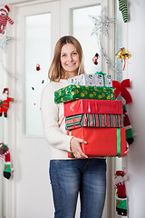 Image showing Woman With Gifts Standing By Door During Christmas