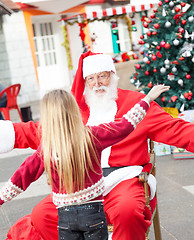 Image showing Santa Claus And Girl About To Embrace