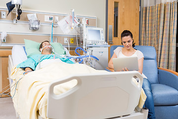 Image showing Woman Using Digital Tablet While Sitting By Patient