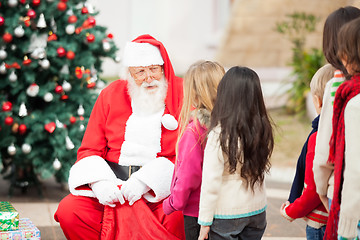 Image showing Santa Claus Looking At Children Standing In A Queue
