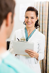 Image showing Doctor With Clipboard Standing By Patient