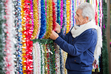 Image showing Man Choosing Tinsels In Christmas Store