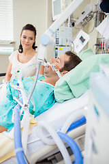 Image showing Woman Looking At Male Patient Resting On Bed