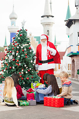 Image showing Santa Claus With Children Opening Presents By Christmas Tree