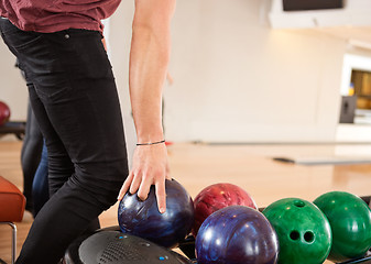 Image showing Young Man Choosing Bowling Ball From Rack