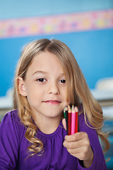 Image showing Girl Holding Bunch Of Color Pencils In Preschool