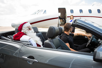 Image showing Santa And Chauffeur In Convertible While Airhostess Against Priv