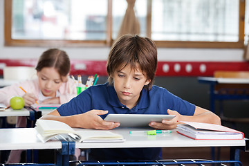 Image showing Schoolboy Using Digital Tablet At Desk