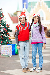 Image showing Friends Wearing Santa Hat Standing In Courtyard