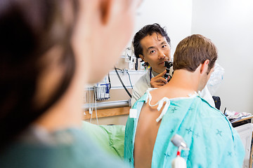 Image showing Doctor With Otoscope Examining Patient's Ear In Hospital