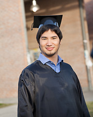 Image showing Male Student In Graduation Gown And Mortar Board On Campus