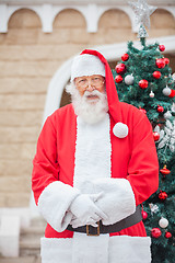 Image showing Santa Claus Against Christmas Tree