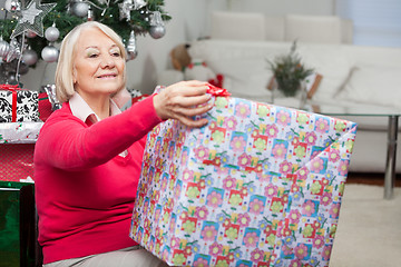 Image showing Senior Woman Opening Christmas Present