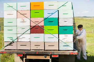 Image showing Beekeeper Standing By Truck Full Of Honeycomb Crates