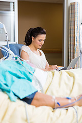 Image showing Woman Using Laptop While Sitting By Patient