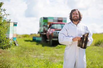 Image showing Beekeeper In Holding Smoker At Apiary