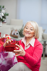 Image showing Senior Woman Looking At Christmas Gift In Bag