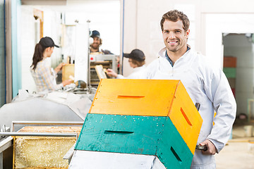 Image showing Handsome Beekeeper With Trolley Of Stacked Honeycomb Crates