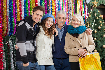 Image showing Family Standing Against Tinsels At Christmas Store