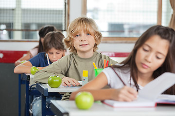 Image showing Schoolboy Sitting In A Row With Classmates At Classroom