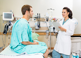 Image showing Doctor Holding Clipboard While Discussing Report With Patient