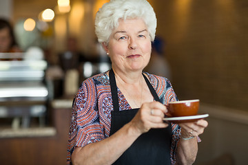 Image showing Waitress Holding Coffee Cup And Saucer In Cafe