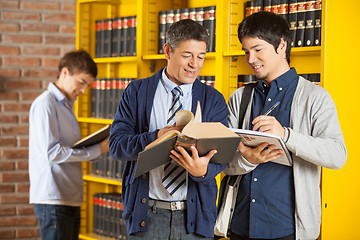 Image showing Librarian Assisting Student In College Library