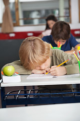 Image showing Tired Schoolboy Sleeping At Desk