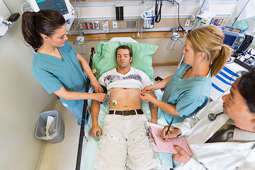 Image showing Nurses And Doctor Examining Patient's Pulse In Hospital