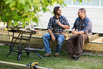 Image showing Carpenters With Disposable Cups Looking At Each Other On Frame