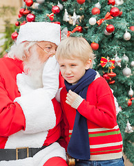 Image showing Santa Claus Whispering In Boy's Ear