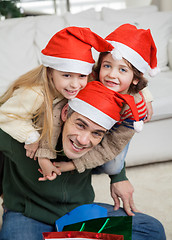 Image showing Father Piggybacking Children During Christmas