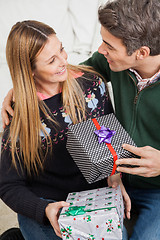 Image showing Couple With Christmas Presents Looking At Each Other