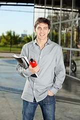 Image showing Student Holding Book And Juice Bottle On Campus