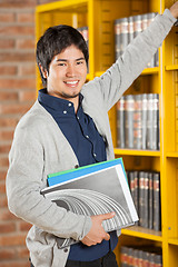 Image showing Male Student Choosing Books In College Library