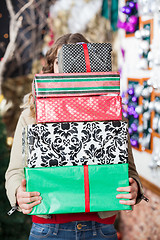 Image showing Woman Hiding Behind Stack Of Christmas Gifts