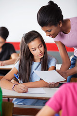 Image showing Teacher Showing Paper To Female University Student At Desk