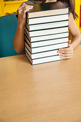 Image showing Student With Stacked Books At Table In College Library