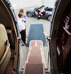 Image showing Santa Waving In Convertible With Pilot And Airhostess In Foregro