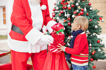 Image showing Santa Claus Giving Present To Boy