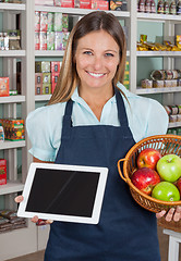 Image showing Saleswoman Holding Digital Tablet And Fruits Basket