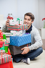 Image showing Man With Stack Of Christmas Presents At Home