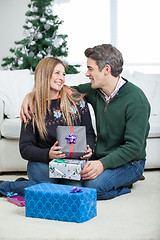 Image showing Couple With Christmas Presents Sitting On Floor