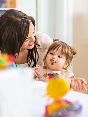 Image showing Mother Looking At Daughter Eating Cupcake