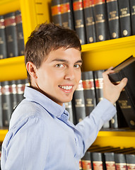 Image showing Handsome Student Choosing Book From Shelf In Library