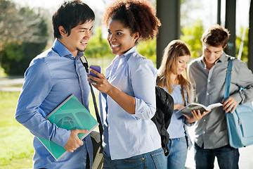 Image showing Happy Friends With Mobilephone And Book In Campus